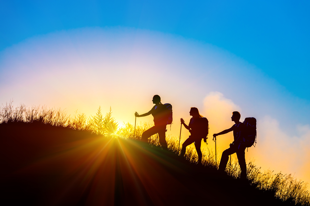 Silhouettes,of,three,people,walking,with,backpacks,and,other,hiking