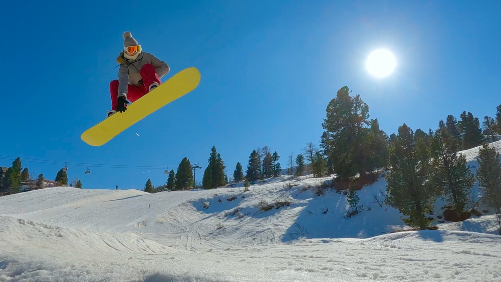 Low,angle,view:,freestyle,female,snowboarder,performing,stylish,indy,grab